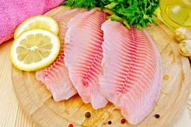 Tilapia with parsley and lemon on board