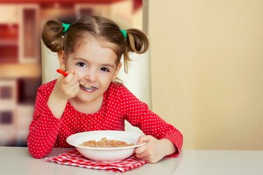 Little girl eating meal.Kid healthy food background.