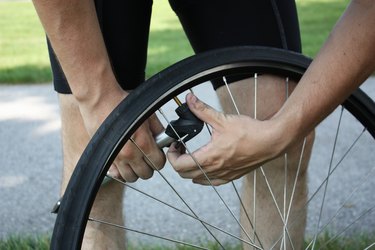 closeup of a man demonstrating how to inflate a presta valve