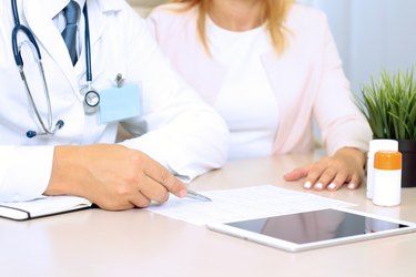 doctor explaining diagnosis to a person wearing a pink cardigan