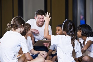 Diverse group of children in gym with coach