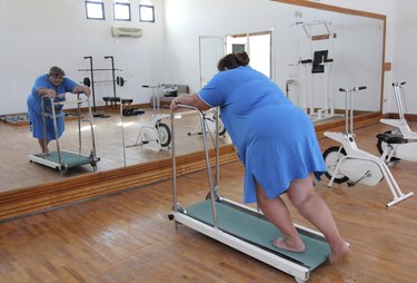 overweight woman running on trainer treadmill