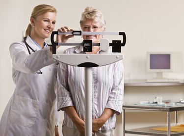 Doctor weighing senior woman