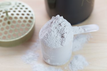 scoop of whey protein on wooden table