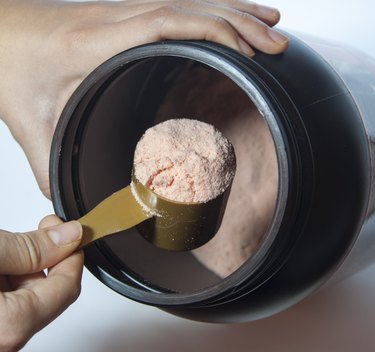 Man taking scoop of protein from black container