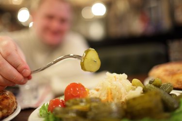 Man taking pickled cucumber