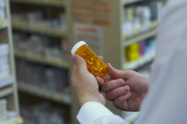 Pharmacist examines a bottle of vitamins