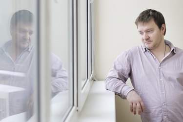 Man looking at snow into the window