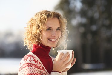 中年成年妇女在雪地里拿着杯子