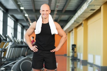 Athletic guy with towel on gym