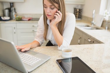 Stressed woman on phone and laptop