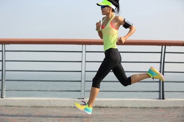 young fitness woman runner running at seaside