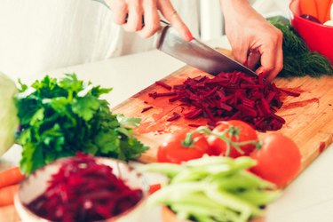 The woman is cooking at the kitchen