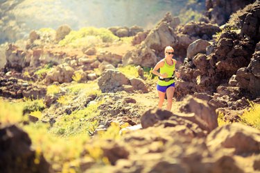 Happy woman running in mountains summer sunset