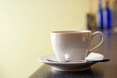 Cup and saucer of coffee on European cafe counter.