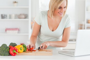 Close up of a woman looking for a recipe on laptop