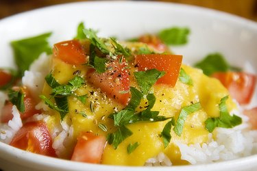 Cooked yellow split peas with tomatoes and white rice in a bowl