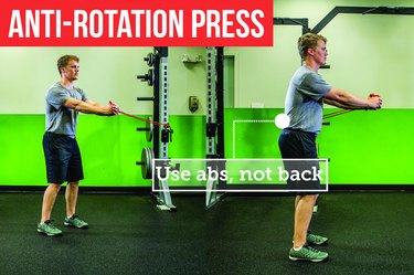 Man doing the anti-rotation press with proper form to prevent back pain