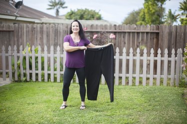Stacy holds a pair of her pants from before her weight loss.