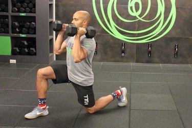 Man doing a dumbbell forward lunge during a 17-minute HIIT workout