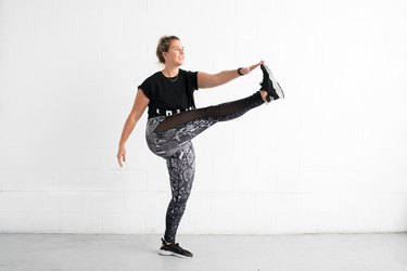 woman doing toe touch kick standing ab exercise
