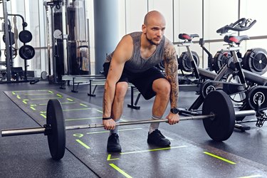 man lifting barbell at the gym