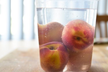 peaches in plastic container with  clear syrup