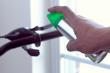 close-up of person spraying hairspray on the grips and handlebars