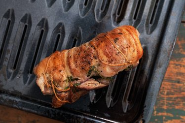 Lamb flaps cooking on a roasting pan with rack