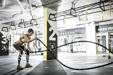 woman doing battle ropes in the gym