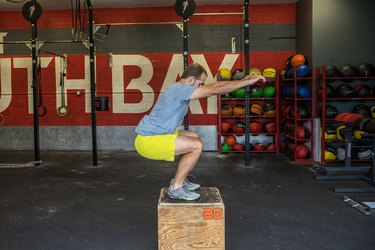 Man demonstrating plyometric box jump exercise for HIIT workout to burn calories