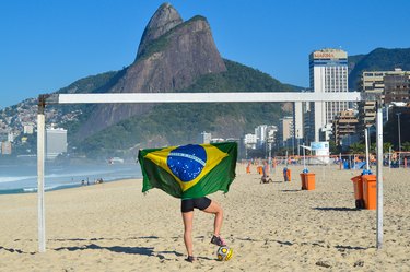 Woman doing workout on beach with Brazilian flag