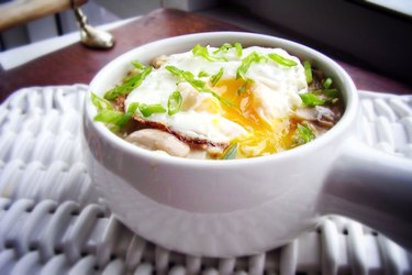 A bowl of oatmeal with herbs, mushrooms and egg