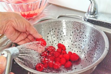 rinsing raspberries in a colander