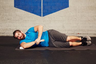 man doing a shoulder stretch in the gym