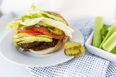 lettuce-wrapped burger with tomatoes and pickles