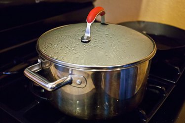 a lid on a pot of boiling water cooking gnocchi