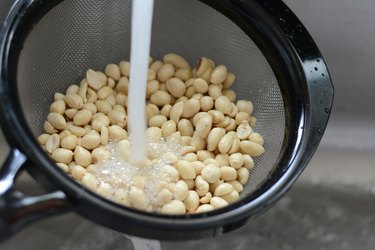 Peanuts being rinsed in colander.