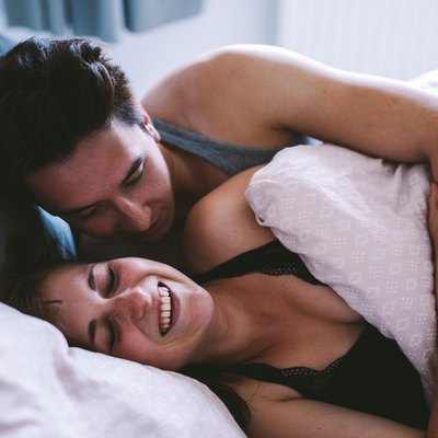 young couple smiling in bed