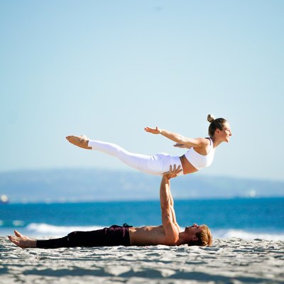 Woman performing back extension on partner's hands.
