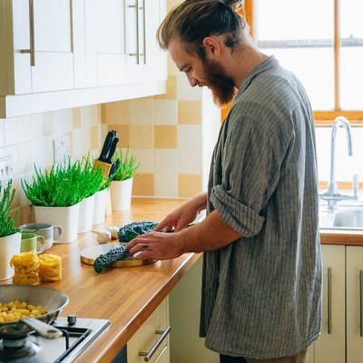 man in kitchen cooking sustainably