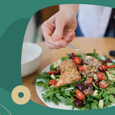 Custom graphic showing hand sprinkling seeds over hearty salad.
