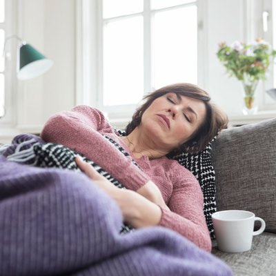 Woman lying on couch and feeling uncomfortable after eating
