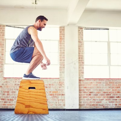 Man box jump squat in the gym