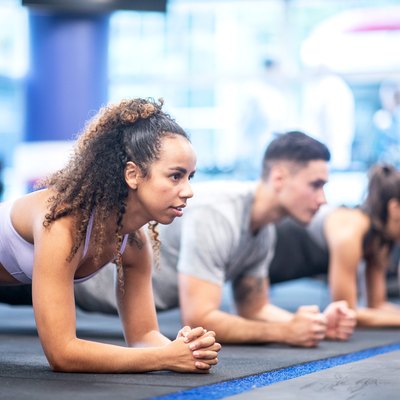 Woman planking in workout class with friends