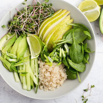 Gluten free quinoa veggie bowl with spinach, sprouts, pear, lime, cucumber and quinoa