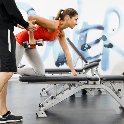 personal trainer working with a client in the gym doing rows