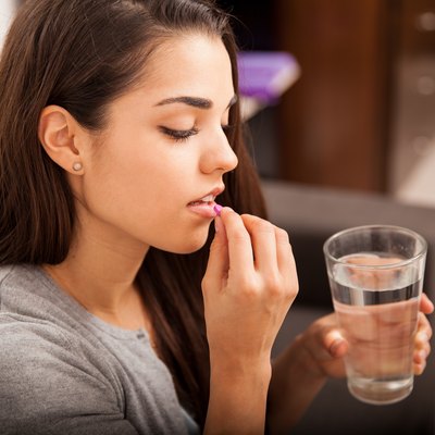 Young woman taking an Adderall pill for ADHD