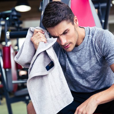 Bodybuilder wipes the sweat at fitness gym