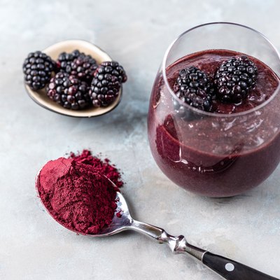 Berry Smoothie with spoon full of vegan protein powder